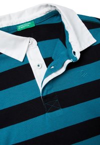 Tealová a černá pruhovaná polokošile s bílým límečkem, s logem a dvěma knoflíky u krku. Měkká bavlněná látka, neformální design.