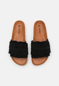 Zwarte slippers met een bovenwerk van suede en een gerimpeld ontwerp. De binnenzool is tan, met een gladde textuur en zichtbare branding. Maat 37.