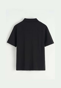 Polo shirt noir à manches courtes avec un col, présenté de dos sur fond clair.