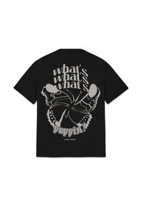 Černé bavlněné tričko s velkým grafickým designem motýla a textem "co se děje?" v různých písmenech a velikostech na zádech.