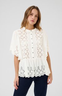 Bela bluzica z detajami cvetličnega broderie anglaise, kratkimi razširjenimi rokavi, sprednjim gumbom in nabranim peplum robom.