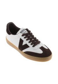 Zapatillas de ante blancas y marrones con un diseño texturizado, que cuentan con punta redonda, cordones marrones y suela de goma. Logo en la lengüeta.