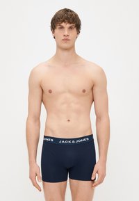 Boxer briefs in cotone blu navy con un elastico bianco in vita recante il nome del marchio "JACK & JONES" ripetuto. Cuciture piatte e design aderente.