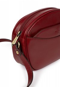 Borsa a tracolla rossa in pelle con forma arrotondata, dotata di chiusura con zip, texture liscia e dettagli in metallo color oro.