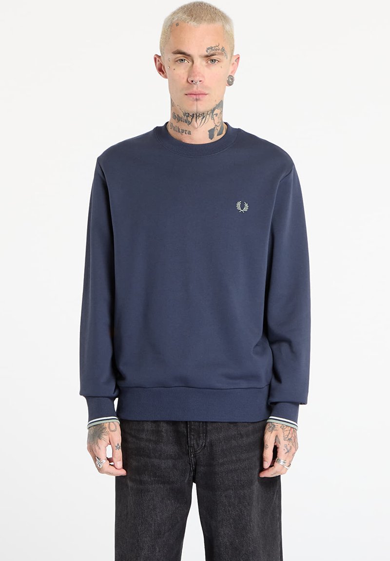 Felpa blu navy in tessuto morbido, con collo a giro e polsini a coste, e un piccolo logo sul petto. Design a vestibilità ampia.