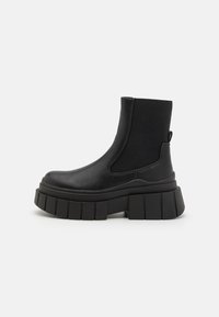 Black ankle boots made of smooth leather with elastic side panels, a chunky platform sole, and a textured tread design.