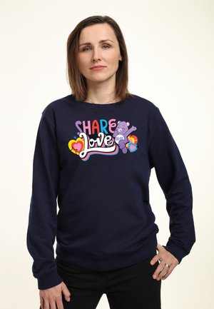 Námořnická modrá mikina s barevným grafickým prvkem, na kterém je nápis "SHARE Love" spolu s kreslenou medvědí postavou a srdíčkovými designy. Dlouhé rukávy a kulatý výstřih.