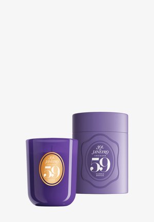 Vela perfumada morada y envase a juego con la etiqueta Sol de Janeiro Cheirosa 59 sobre un fondo blanco.