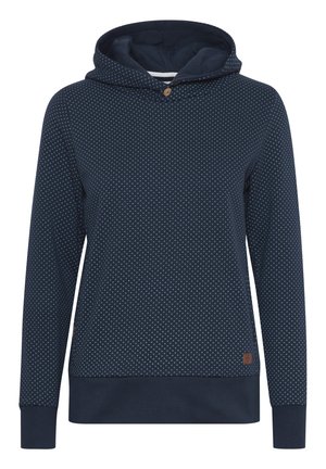 Marineblå hettegenser med prikkete mønster, snorhette, en treknapp og ribbestrikkede mansjetter og hem som gir en tett passform. Myk tekstur.