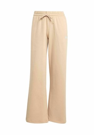 Pantaloni della tuta beige con un design a gamba larga, vita con cordino elastico e branding discreto. Tessuto morbido con una consistenza liscia.
