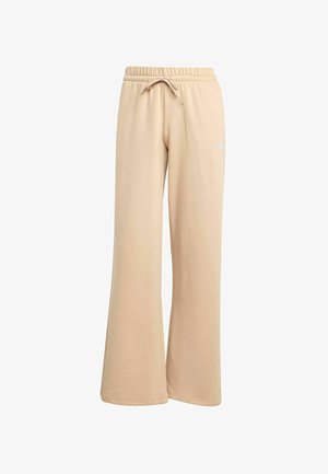 Pantaloni della tuta beige con un design a gamba larga, vita con cordino elastico e branding discreto. Tessuto morbido con una consistenza liscia.