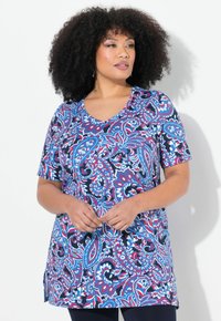 Tunique à manches courtes dans un motif paisley bleu vif, rouge et blanc, avec un col en V et une coupe ample dotée d fentes latérales.