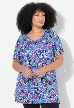 Tunic a maniche corte in un vivace motivo paisley blu, rosso e bianco, con scollatura a V e una vestibilità ampia dotata di spacchi laterali.