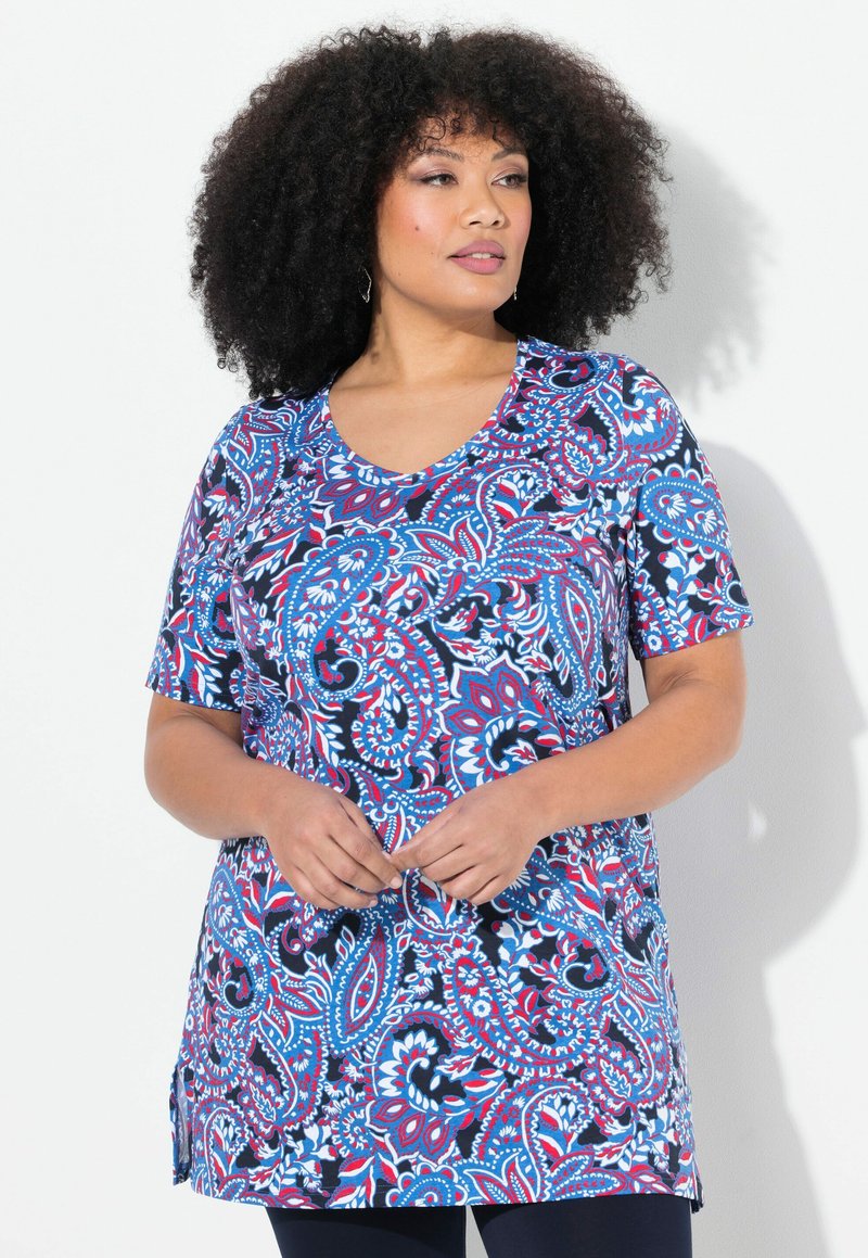 Tunique à manches courtes dans un motif paisley bleu vif, rouge et blanc, avec un col en V et une coupe ample dotée d fentes latérales.