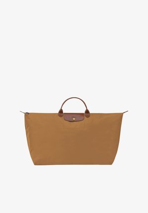 Large brown nylon tote bag with a leather top handle, featuring a front flap pocket and a zip closure. Minimalist design with a smooth texture.