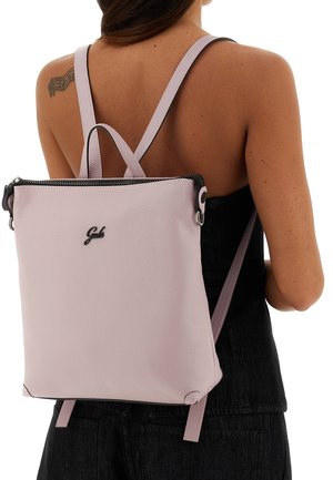 Zaino in pelle rosa chiaro con finitura testurizzata, dettagli con cerniere nere, spallacci regolabili e logo del marchio sulla parte anteriore.