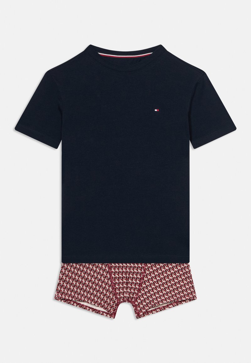 Σκούρο μπλε ναυτικό κοντομάνικο πουκάμισο συνδυασμένο με κόκκινα μποξεράκια με σχέδιο, τοποθετημένα επίπεδα σε λευκό φόντο.