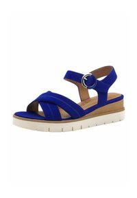 Blue suede sandal with crisscross straps, adjustable ankle buckle, and a white platform sole with textured detail.