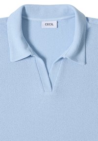 Polo tricoté bleu clair avec un col souple et une ouverture en V à l’avant, avec une étiquette de marque "CECIL" à l’intérieur du col.