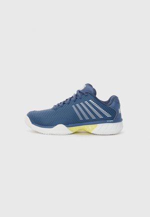 Baskets de sport bleues avec une tige texturée, des accents blancs et une semelle intercalaire jaune. Comprend un col rembourré et un design de semelle courbée.