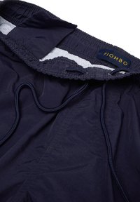 Pantaloni corti blu navy con vita elastica regolabile, foderati in rete e etichetta "PIOMBO". Tessuto liscio e dettaglio di cucitura arricciata.
