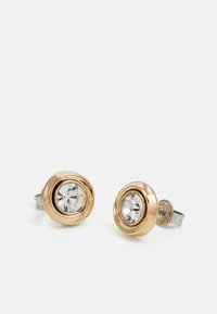 Boucles d'oreilles en métal doré avec un clou central en cristal clair dans un sertissage circulaire surélevé, avec un dos en métal argenté.