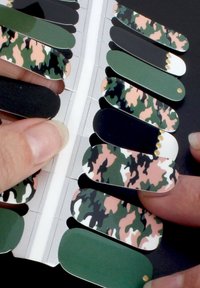 Autocollants pour nail art présentant une variété de motifs de camouflage en vert, noir et rose, avec des bords arrondis et une finition brillante.