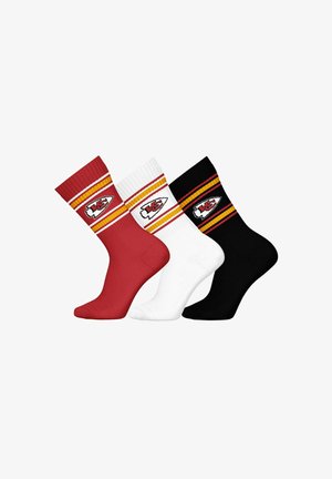 Tres pares de calcetines de tripulación en rojo, blanco y negro, con bordes acanalados, rayas amarillas y rojas, y un parche de logo en cada calcetín.