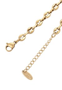 Gouden ketting met ovale schakels en een kreeftsluiting. Bevat een klein label met de gravure "WLT" bevestigd aan een schakel.