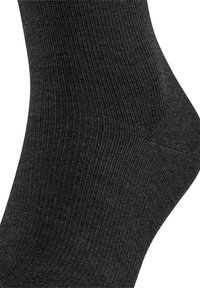 Svart strumpa med ribbat mönster och slät yta, med förstärkt häl och tå för hållbarhet. Lätt avsmalnande form.