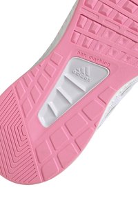 Suola di sneaker Adidas in gomma rosa e materiale bianco non marcante. Presenta motivi testurizzati e scanalature per trazione e supporto.