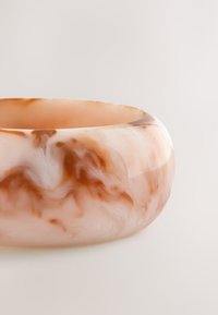 Translucent pink marble bowl with swirling patterns of cream and light brown. Smooth texture, rounded shape, and no visible accents.