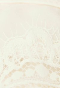 Lace fabric in cream color with intricate floral and geometric patterns, featuring a soft, smooth texture and delicate detailing.