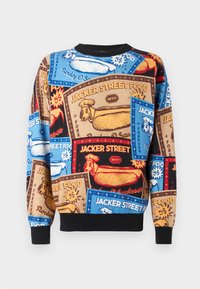 Multicolored sweatshirt featuring bold hot dog graphics and text on a textured fabric. Black ribbed collar and cuffs. Graphic design throughout.