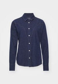 Granatowa koszula dżinsowa z długimi rękawami, spiczastym kołnierzykiem i białymi guzikami. Posiada zaokrąglony detal na karku oraz lekko zaokrąglony dół.