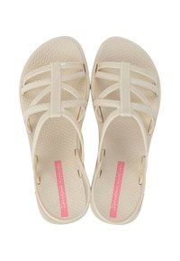 Sandali beige con più cinturini, suola testurizzata e dettagli in logo rosa. Leggeri e realizzati con materiale flessibile.
