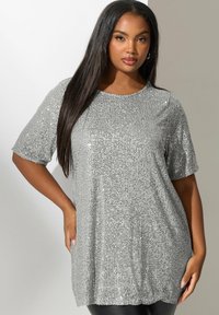 Top plateado con lentejuelas, de mangas cortas, cuello redondo, corte holgado y textura suave. Las lentejuelas crean un efecto brillante.