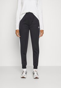 Fila RADIA TAPERED TRACK PANTS - Calças de fato de treino - black/bright white