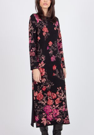 Black floral dress with long sleeves, featuring vibrant pink and red floral patterns, side slits, and a fitted silhouette. Soft fabric texture.