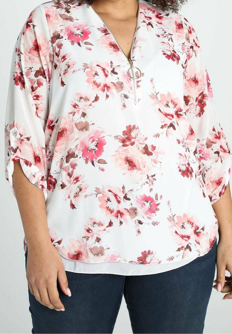 Blusa floreale bianca con fiori rosa e borgogna, con scollo a zip e maniche arrotolate. Tessuto liscio con vestibilità rilassata.