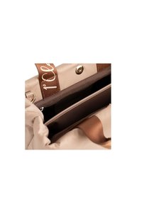 Borsa beige con una morbida texture a increspature. Presenta hardware dorato, una tracolla marrone con branding e una tasca interna con zip.