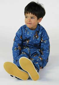 Zila sporta krekla un biksēm komplekts ar ziemeļbriežu rakstu un sniegpārsliņām. Mīksta auduma, ribota apkakle un aproces, baltas zoles uz melnām kurpēm.