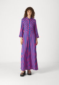Robe longue à boutons avec des rayures verticales roses et bleues audacieuses, fabriquée en tissu lisse, avec une taille froncée et des manches longues.
