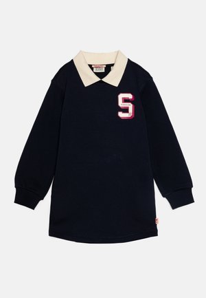 Navyblauw shirt met lange mouwen, witte kraag, roze en witte "S" patch op de borst en geribbelde manchetten, plat gelegd op een witte achtergrond.