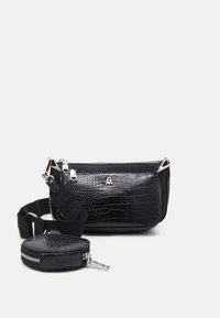 Czarna torebka crossbody z sztucznej skóry krokodyla z srebrnymi zamkami, małym logotypem, szerokim regulowanym paskiem z tkaniny oraz odczepianą okrągłą kieszonką na monety.