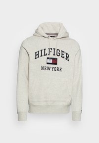 Světle šedá mikina s kapucí vyrobená z měkké tkaniny. Obsahuje stahovací kapuci, přední klokankovou kapsu a silný potisk "HILFIGER NEW YORK".