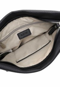 Black leather handbag interior, featuring a light beige fabric liner, zip pocket, and a small label. Smooth texture and structured shape.