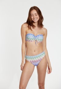 Daugiaspalvis bikini su zigzago raštu mėlynos, žalios ir purpurinės spalvų. Viršus turi pynimo detalę centre.