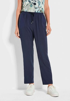 Pantalon de jogging léger bleu marine avec une taille élastique et un cordon de serrage. Présente un design à jambe droite et est porté avec des baskets blanches.
