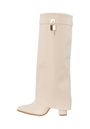 Bota de cuero beige hasta la rodilla con punta cuadrada, tacón grueso y detalle de candado dorado cerca del borde superior.